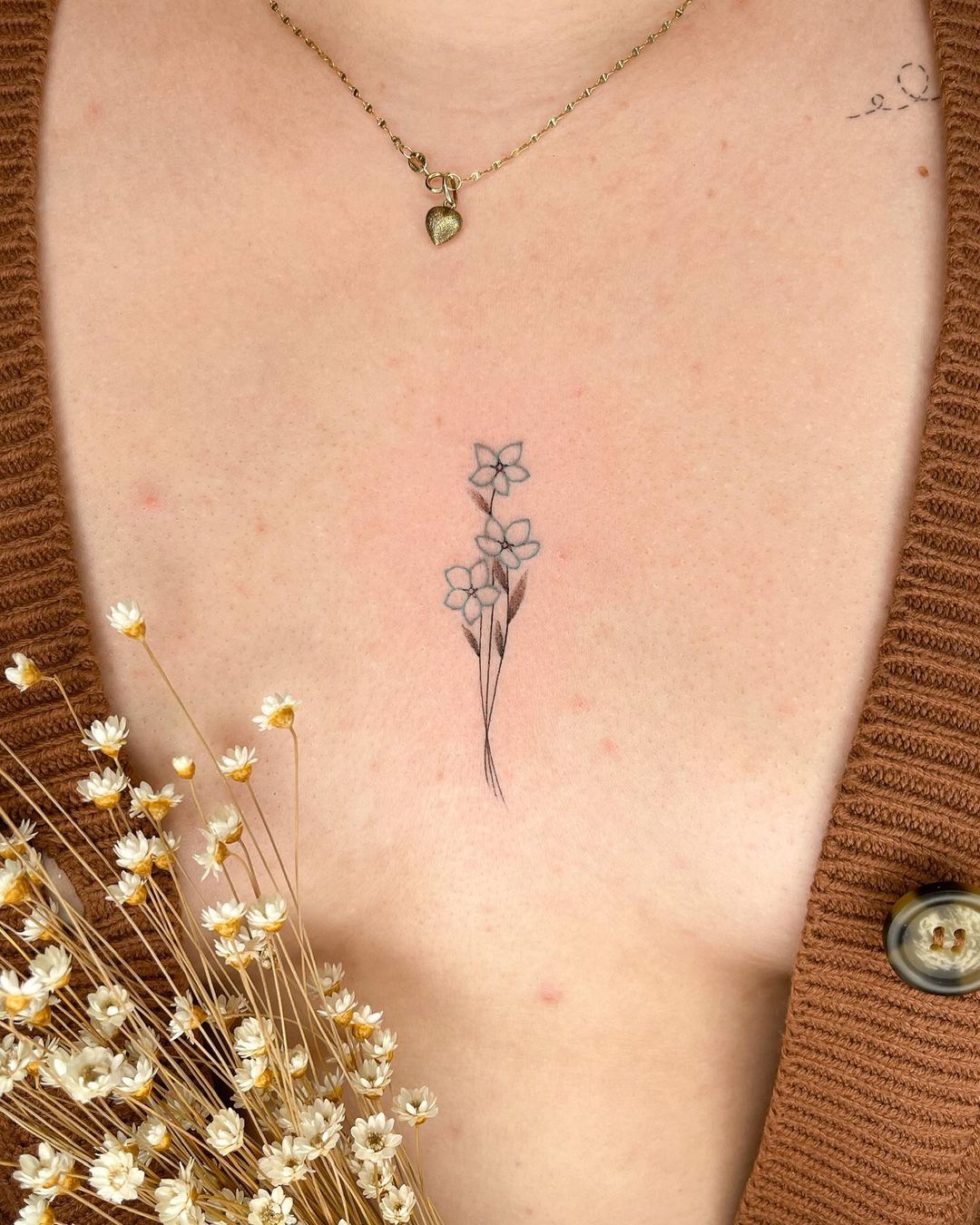 Dainty small chest tattoo motifs.