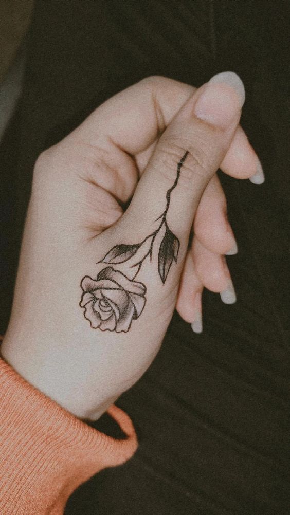 Small rose tattoo with name stem is a meaningful design choice for all